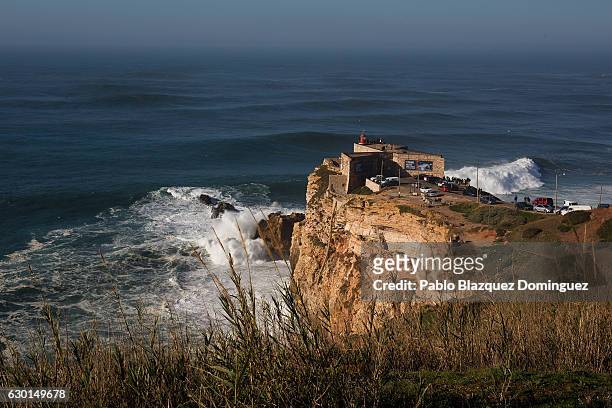 Members of the public watch a big waves session from the lighthouse at Praia do Norte on December 17, 2016 in Nazare, Portugal. Nazare's giant waves...