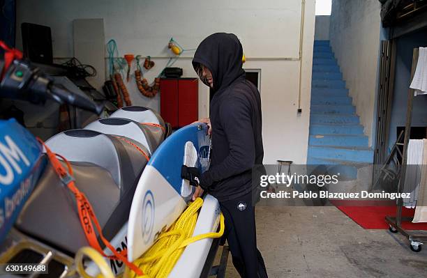 Russian surfer Andrey Karr Boldyrev packs his board on the jet ski before a big waves session on December 17, 2016 in Nazare, Portugal. Nazare's...