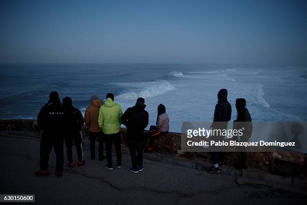 Surfers check the waves in the early hours before they have a big waves session at Praia do Norte on December 17, 2016 in Nazare, Portugal. Nazare's...