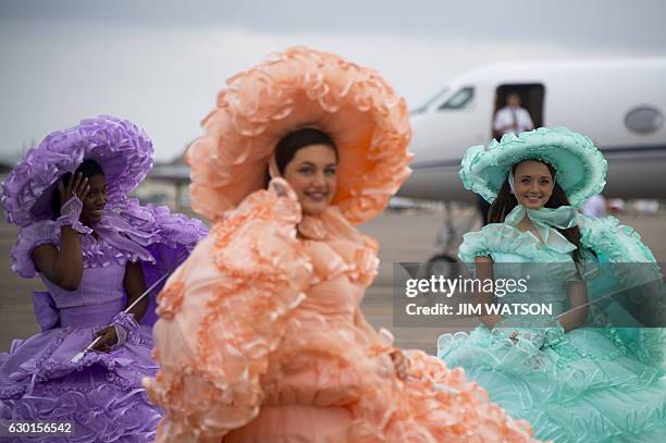 Azalea Trail Maids smile as US President-elect Donald Trump arrives in Mobile, Alabama, for a 'Thank You Tour 2016' rally on December 17, 2016. / AFP...