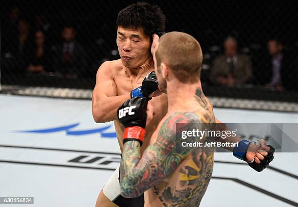 Eddie Wineland punches Takeya Mizugaki of Japan in their bantamweight bout during the UFC Fight Night event inside the Golden 1 Center Arena on...