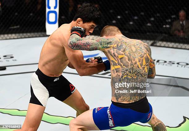 Eddie Wineland punches Takeya Mizugaki of Japan in their bantamweight bout during the UFC Fight Night event inside the Golden 1 Center Arena on...