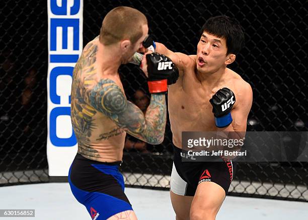 Takeya Mizugaki of Japan punches Eddie Wineland in their bantamweight bout during the UFC Fight Night event inside the Golden 1 Center Arena on...