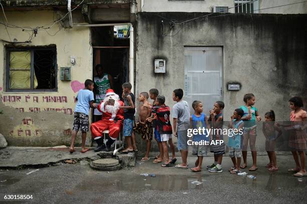 Leandro Souza who lives in the favela da Mare complex, one of the most violents in Rio de Janeiro, dresses as Santa Claus to distribute gifts to the...