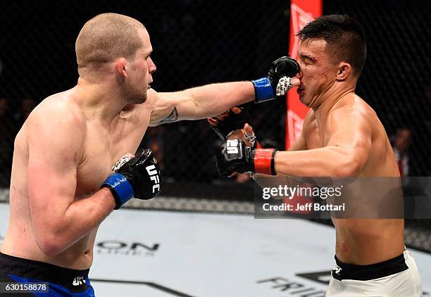 Alex Morono punches James Moontasri in their welterweight bout during the UFC Fight Night event inside the Golden 1 Center Arena on December 17, 2016...