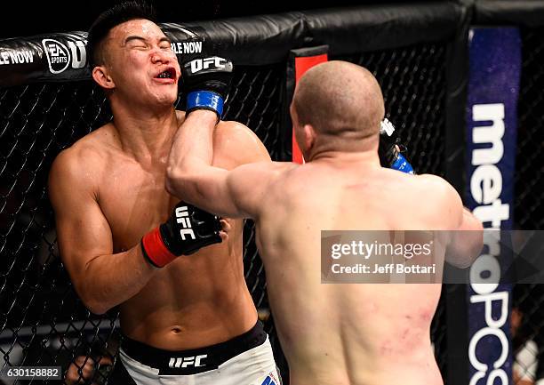 Alex Morono punches James Moontasri in their welterweight bout during the UFC Fight Night event inside the Golden 1 Center Arena on December 17, 2016...