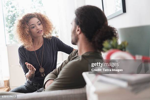 young couple arguing at home - fighting couple stock-fotos und bilder