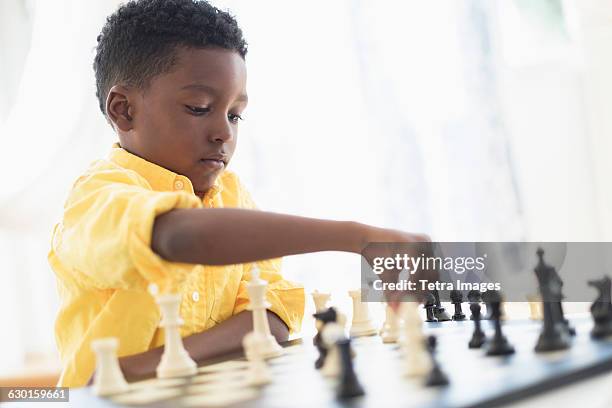 boy (6-7) playing chess - kids playing chess stock pictures, royalty-free photos & images