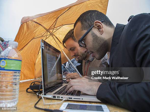 Reporter Sopan Deb tries to stay dry in the rain as president-elect Donald Trump speaks during a thank you rally in Ladd-Peebles Stadium on December...