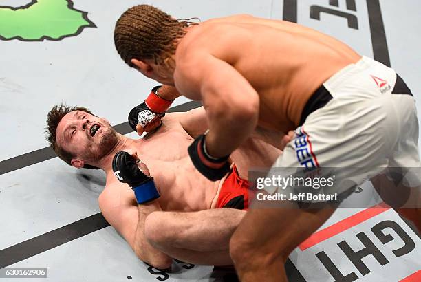 Urijah Faber punches Brad Pickett of England in their bantamweight bout during the UFC Fight Night event inside the Golden 1 Center Arena on December...
