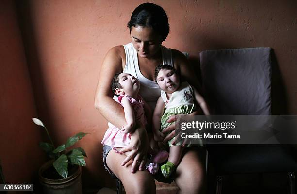 Mother Raquel holds her twin daughters Eloa and Eloisa, 8 months old and both born with microcephaly, while posing on December 16, 2016 in Areia,...