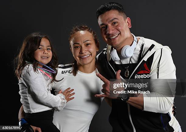 Michelle Waterson, her daughter Araya, and her husband Joshua Gomez pose for a portrait backstage after her victory over Paige VanZant during the UFC...