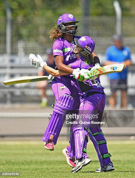 Erin Burns of the Hurricanes is congratulated by Hayley Matthews after hitting the winning runs in the super over during the WBBL match between the...