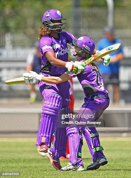 Erin Burns of the Hurricanes is congratulated by Hayley Matthews after hitting the winning runs in the super over during the WBBL match between the...