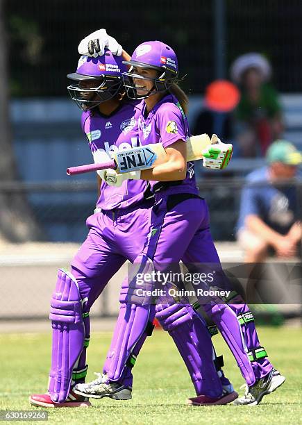 Erin Burns of the Hurricanes is congratulated by Hayley Matthews after hitting the winning runs in the super over during the WBBL match between the...