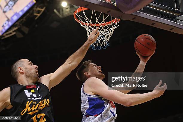 Matt Hodgson of the Adelaide 36ers lays up a shot under pressure from Aleks Maric of the Kings during the round 11 NBL match between Sydney and...