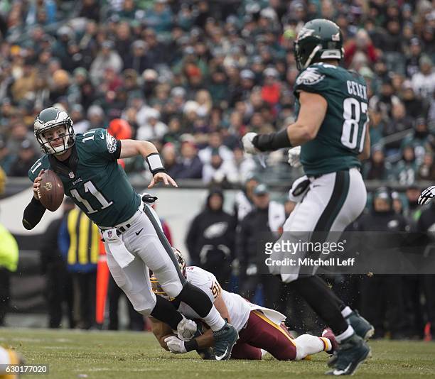 Carson Wentz of the Philadelphia Eagles looks to pass the ball to Brent Celek with Ryan Kerrigan of the Washington Redskins defending on the play at...