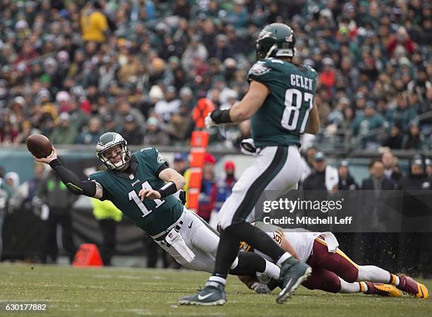 Carson Wentz of the Philadelphia Eagles looks to pass the ball to Brent Celek with Ryan Kerrigan of the Washington Redskins defending on the play at...