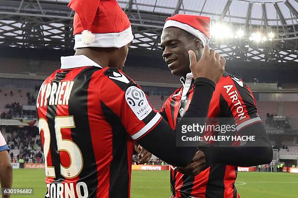 Nice's Italian forward Mario Balotelli and Nice's French midfielder Wylan Cyprien wearing Santa Claus bonnets, celebrate at the end of the French L1...