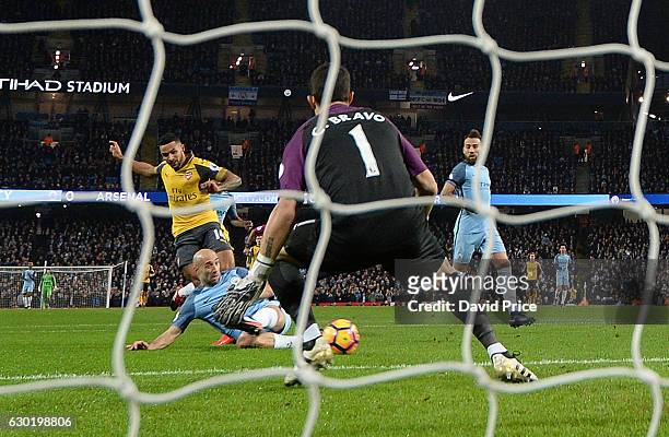 Theo Walcott scores a goal for Arsenal past Claudio Bravo of Man City during the Premier League match between Manchester City and Arsenal at Etihad...