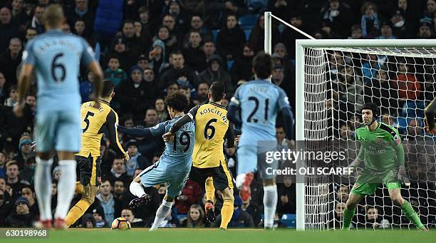 Manchester City's German midfielder Leroy Sane scores his team's first goal past Arsenal's Czech goalkeeper Petr Cech during the English Premier...