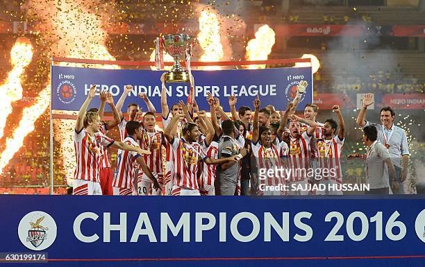 Atletico de Kolkata players celebrate with the trophy after winning the Indian Super League final football match against Kerala Blasters FC at the...
