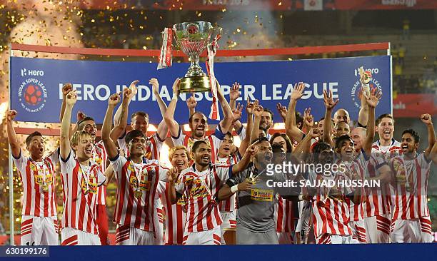 Atletico de Kolkata players celebrate with the trophy after winning the Indian Super League final football match against Kerala Blasters FC at the...