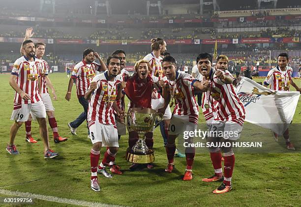 Atletico de Kolkata players celebrate with the trophy after winning the Indian Super League final football match against Kerala Blasters FC at the...