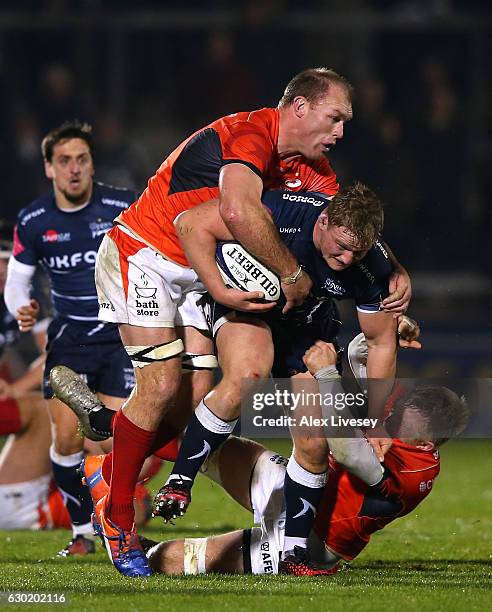 Ross Harrison of Sale Sharks is tackled by Schalk Burger of Saracens during the European Rugby Champions Cup match between Sale Sharks and Saracens...