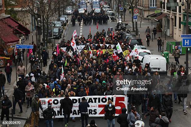People, including refugees and immigrants attend a parade to show solidarity with refugees and immigrants on the International Migrants Day in Paris,...