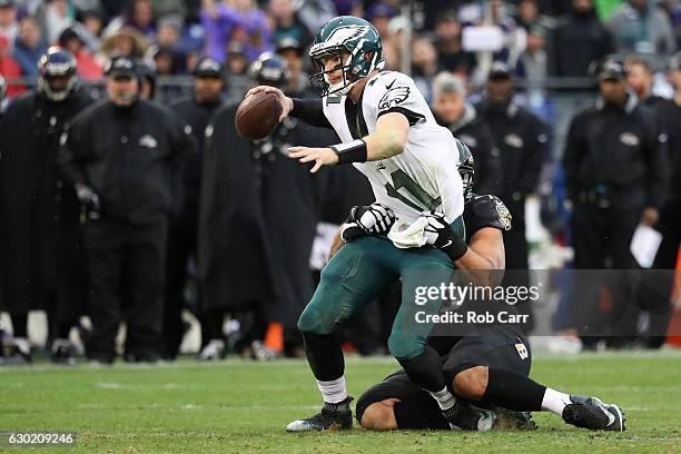 Quarterback Carson Wentz of the Philadelphia Eagles is pulled down by defensive end Lawrence Guy of the Baltimore Ravens in the second quarter at M&T...