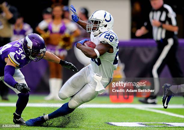 Jordan Todman of the Indianapolis Colts carries the ball while Andrew Sendejo of the Minnesota Vikings dives to tackle him in the third quarter of...