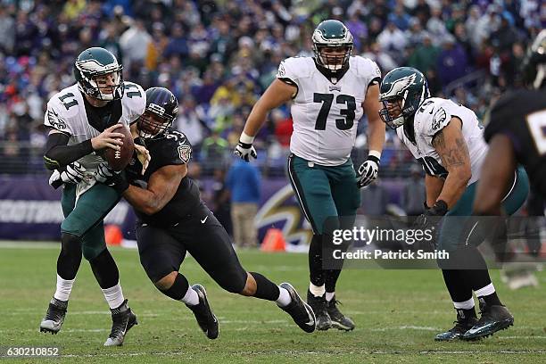 Quarterback Carson Wentz of the Philadelphia Eagles carries the ball against defensive end Lawrence Guy of the Baltimore Ravens in the second quarter...