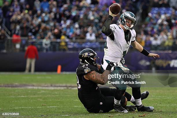 Quarterback Carson Wentz of the Philadelphia Eagles is pulled down by defensive end Lawrence Guy of the Baltimore Ravens in the second quarter at M&T...