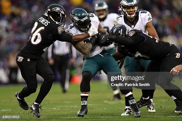 Running back Ryan Mathews of the Philadelphia Eagles is tackled by defensive back Jerraud Powers and inside linebacker C.J. Mosley of the Baltimore...