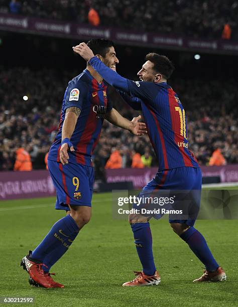 Lionel Messi of FC Barcelona celebrates with his team mate Luis Suarez after scoring his team's fourth goal during the La Liga match between FC...