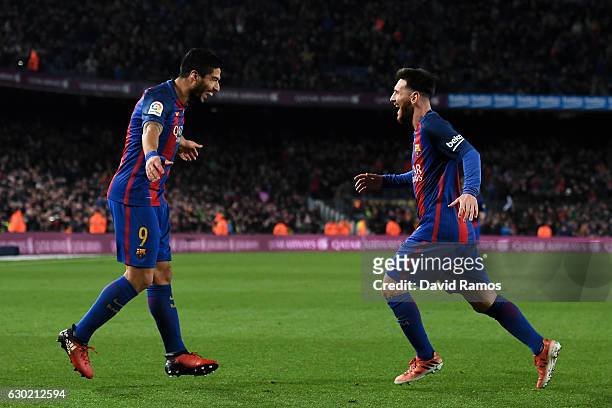Lionel Messi of FC Barcelona celebrates with his team mate Luis Suarez after scoring his team's fourth goal during the La Liga match between FC...