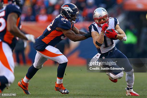 Wide receiver Julian Edelman of the New England Patriots is hit by inside linebacker Corey Nelson of the Denver Broncos after a second quarter catch...