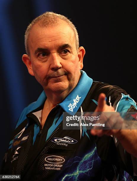 Phil Taylor of England celebrates victory following his first round match against David Platt of England during Day Four of the 2017 William Hill PDC...