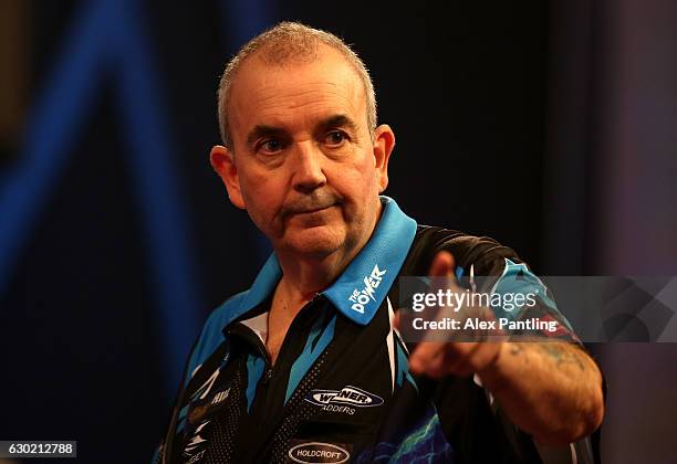 Phil Taylor of England celebrates victory following his first round match against David Platt of England during Day Four of the 2017 William Hill PDC...