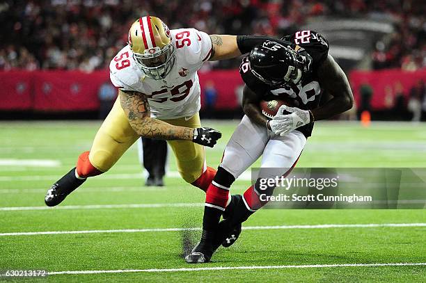 Tevin Coleman of the Atlanta Falcons is tackled by Aaron Lynch of the San Francisco 49ers during the first half at the Georgia Dome on December 18,...