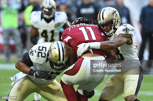 Outside linebacker Craig Robertson and free safety Vonn Bell of the New Orleans Saints tackles wide receiver Larry Fitzgerald of the Arizona...