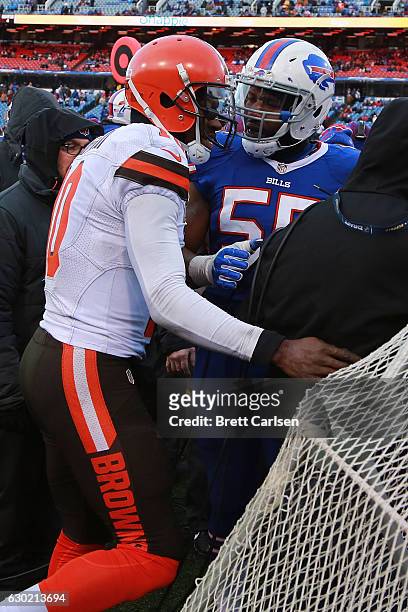 Jerry Hughes of the Buffalo Bills takes issue with Robert Griffin III of the Cleveland Browns running over a camera man during the second half at New...