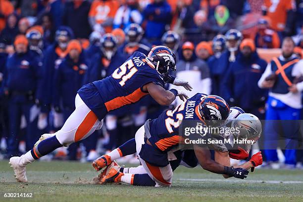 Wide receiver Julian Edelman of the New England Patriots is tackled by inside linebacker Corey Nelson and inside linebacker Todd Davis of the Denver...