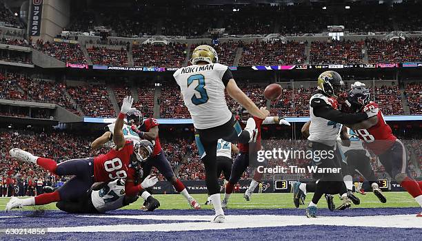 Brad Nortman of the Jacksonville Jaguars punts the ball from his endzone as Stephen Anderson of the Houston Texans and Alfred Blue of the Houston...