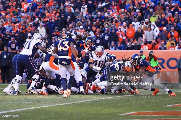 Running back LeGarrette Blount of the New England Patriots dives into the end zone for a second quarter 1-yard rushing touchdown while defended by...