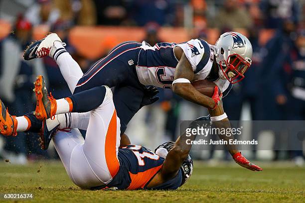 Running back Dion Lewis of the New England Patriots is tackled by inside linebacker Corey Nelson of the Denver Broncos at Sports Authority Field at...