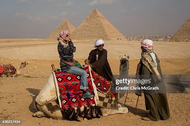 Tourists prepares to take a camel ride at Egypt's famous Giza Pyramids on December 18, 2016 in Cairo, Egypt. Since the 2011 Arab Spring and continued...