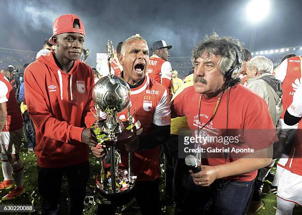 An assitant of Santa Fe celebrates with the trophy after a second leg final match between Santa Fe and Deportes Tolima as part of Liga Aguila II 2016...