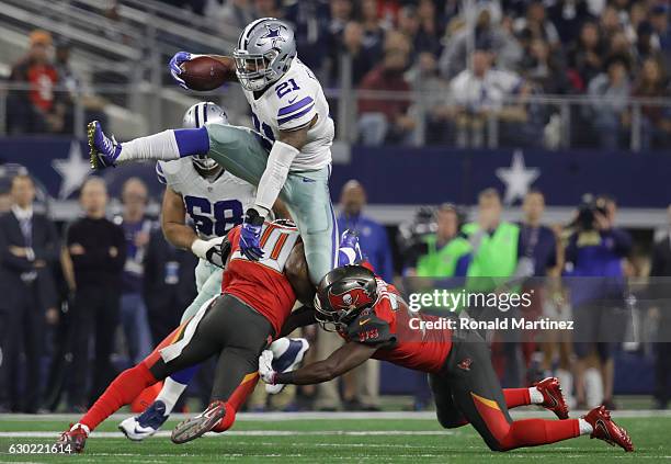 Ezekiel Elliott of the Dallas Cowboys jumps over the attempted tackle by Bradley McDougald and Keith Tandy of the Tampa Bay Buccaneers in the first...